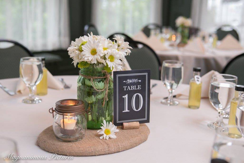 candle, mason jar with daisies on burlap stand