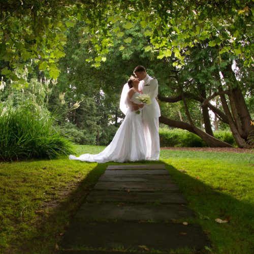 nathan and jayme embrace under grape arbor