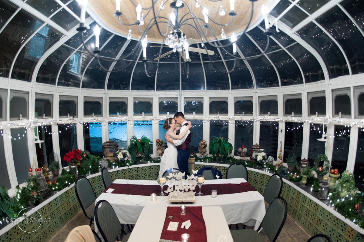 couple-holding-each-other-in-glass-conservatory-for-christmas-wedding