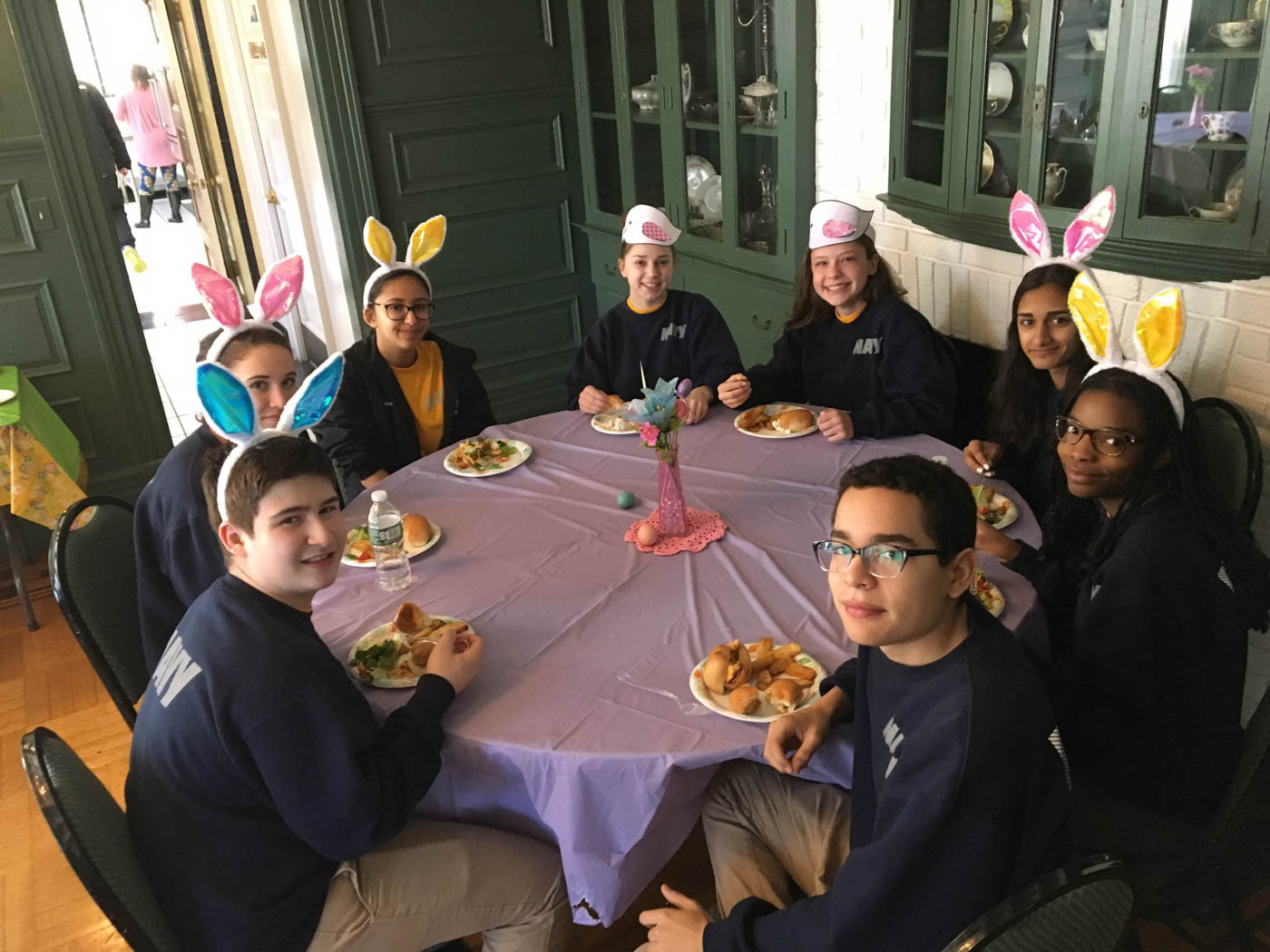 fundraising-volunteers-sitting-around-table-eating-with-bunny-ears-on