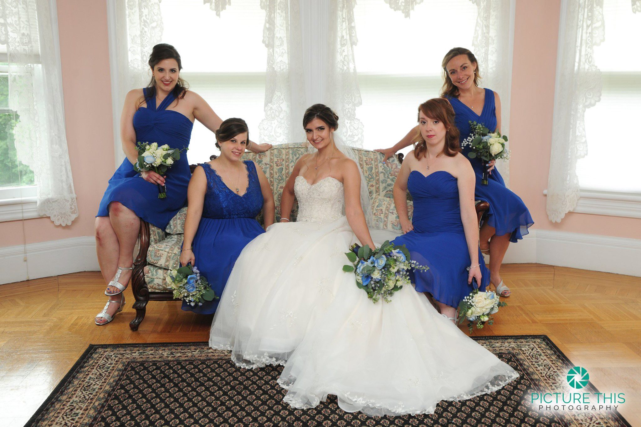 late-june-wedding-party-bride-sitting-with-bridesmaids