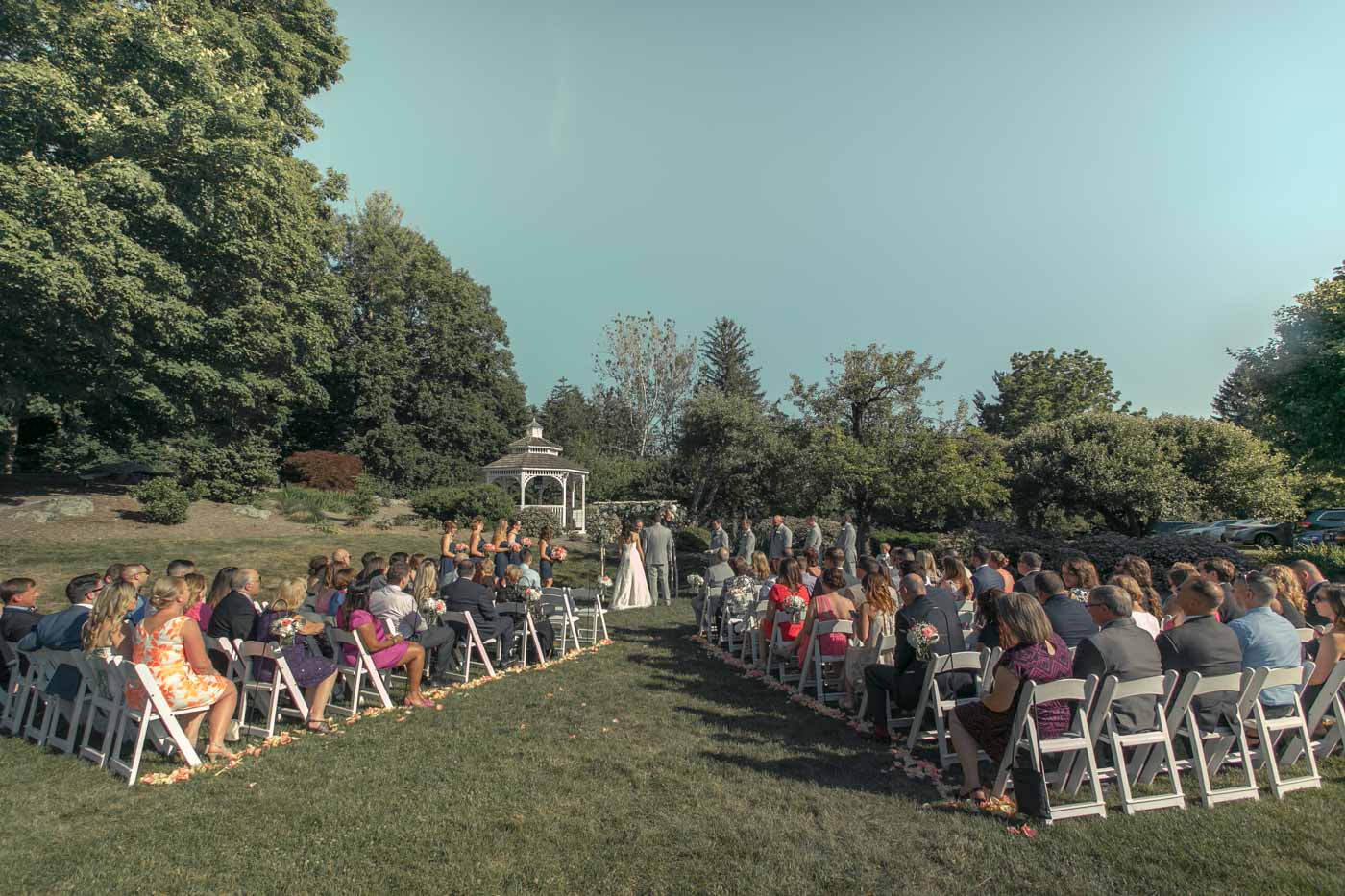 summer-ceremony-guests-seated-on-lawn-gazebo-in-background