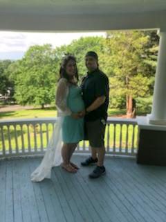 pregnant mom and dad holding each other on the veranda