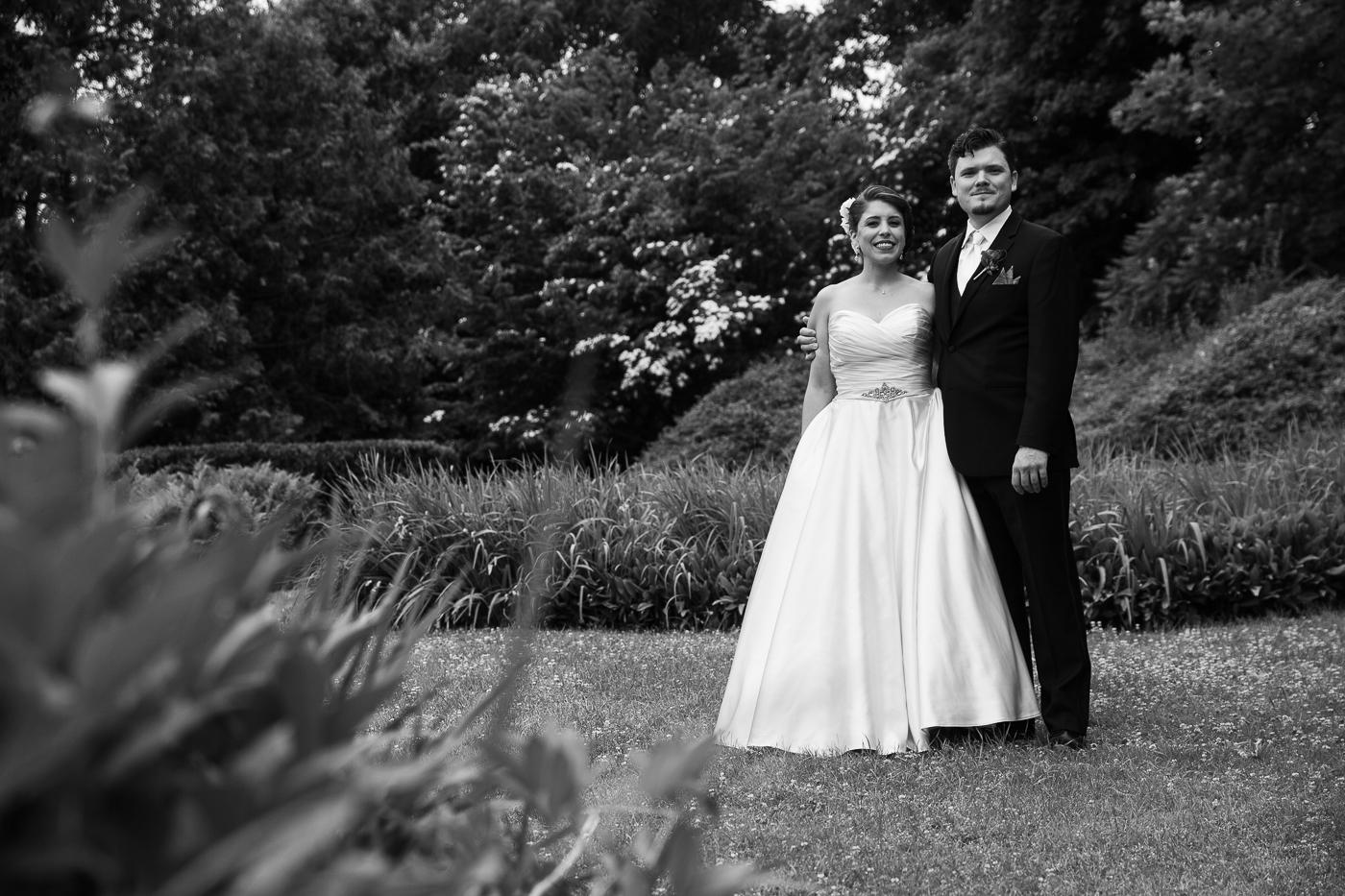 bride and groom posing in flower garden