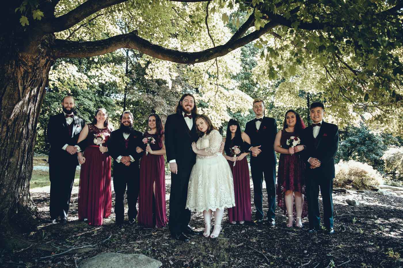 bride, groom and wedding party gathered in the serenity garden