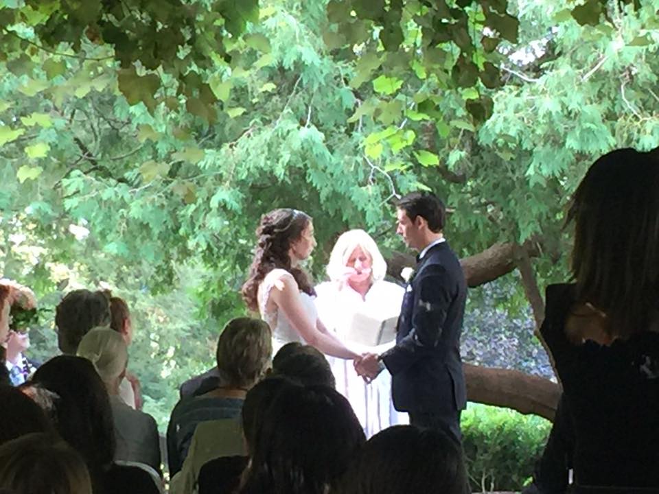 couple holding hands in front of the jp under the grape arbor