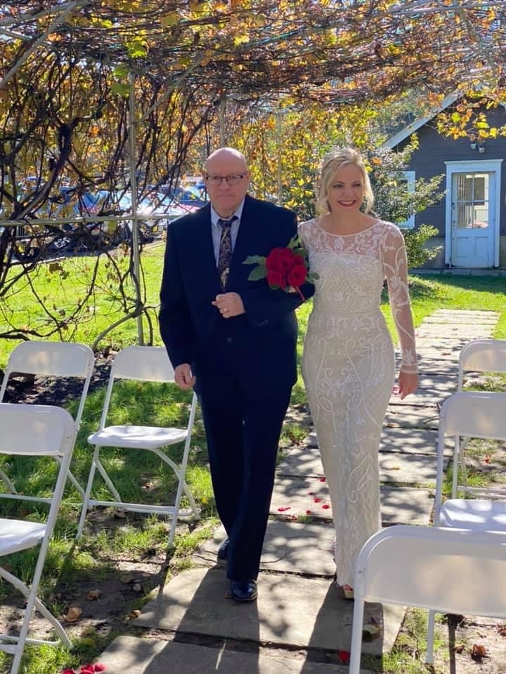 julia and dad walking arm in arm under grape arbor